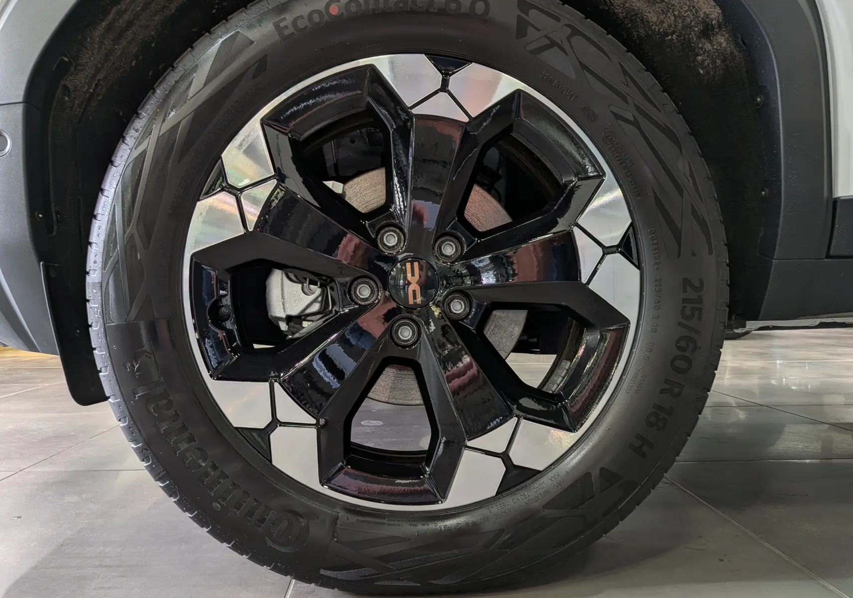 Gros plan sur la roue avant droite du Dacia Bigster blanc Glacier, jante alliage bicolore noire et argentée.