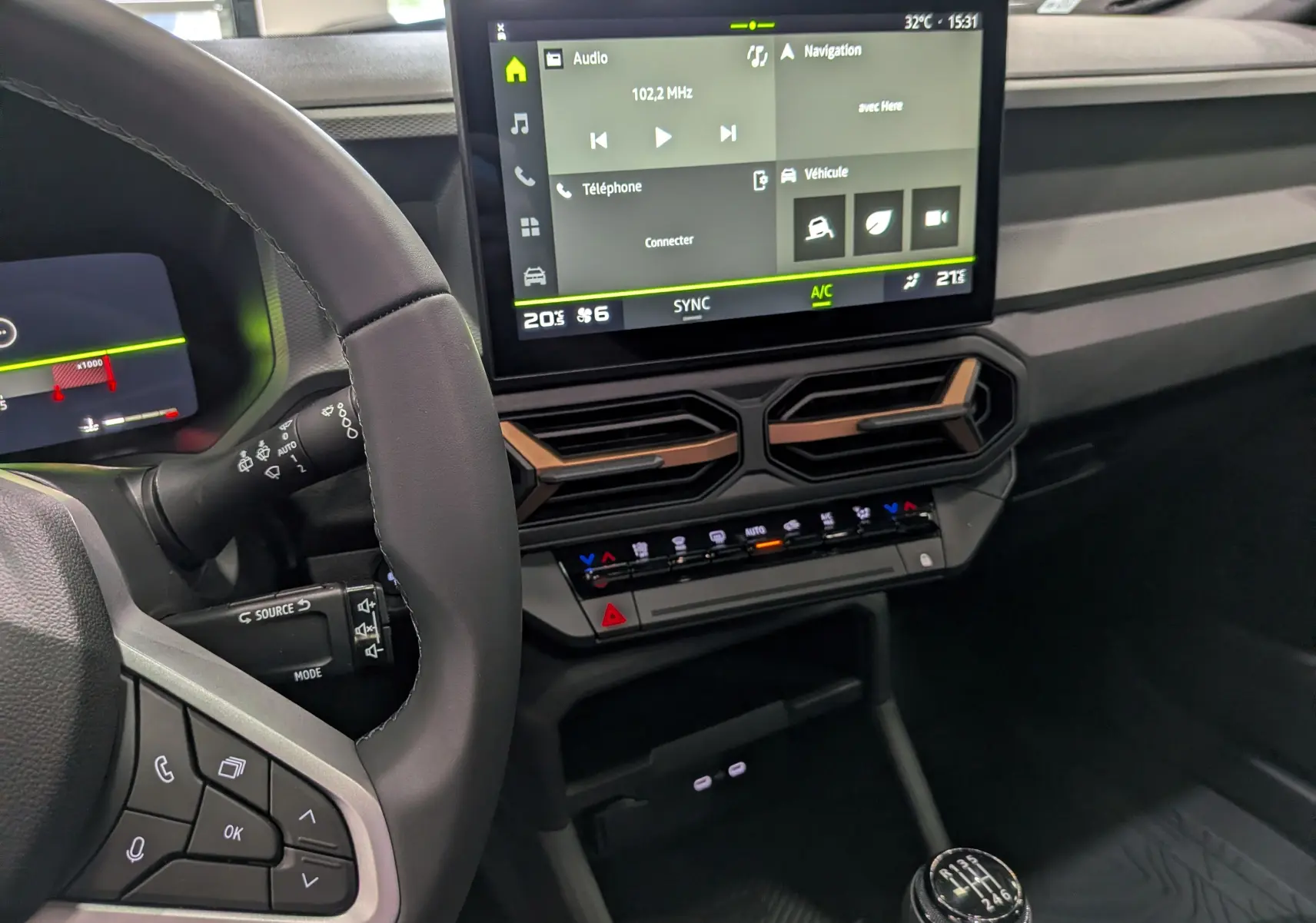 Vue intérieure du tableau de bord du Dacia Bigster 2026, avec écran tactile central et volant partiel en cuir noir.