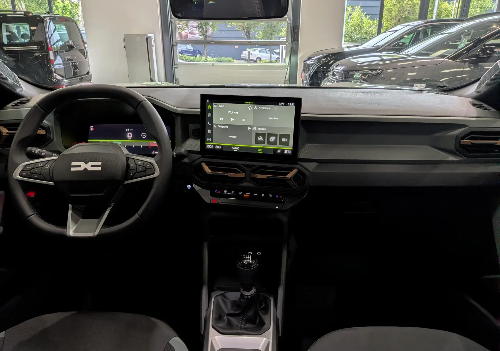 Vue intérieure du tableau de bord du Dacia Bigster 2026, avec écran tactile central et volant multifonction noir.