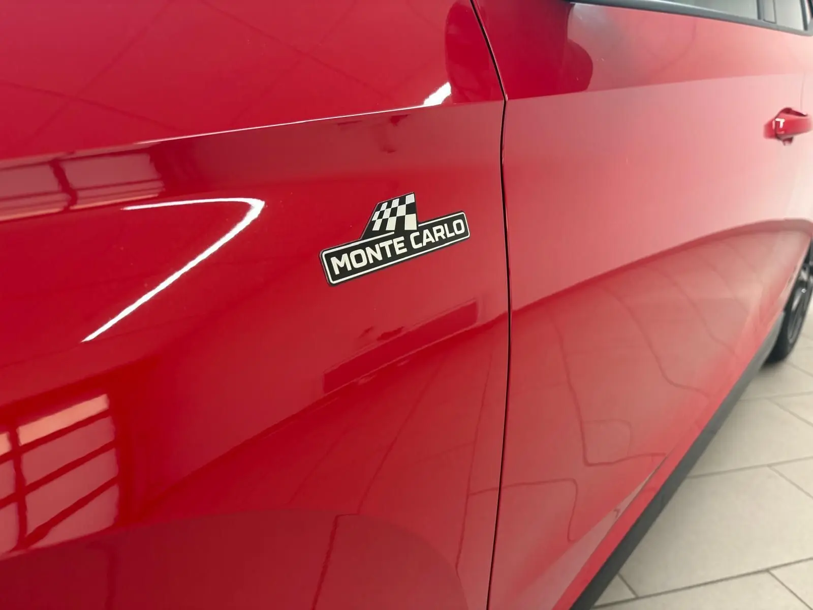 Gros plan sur le côté gauche rouge velvet d'une Skoda Fabia Monte Carlo avec logo distinctif noir et blanc.