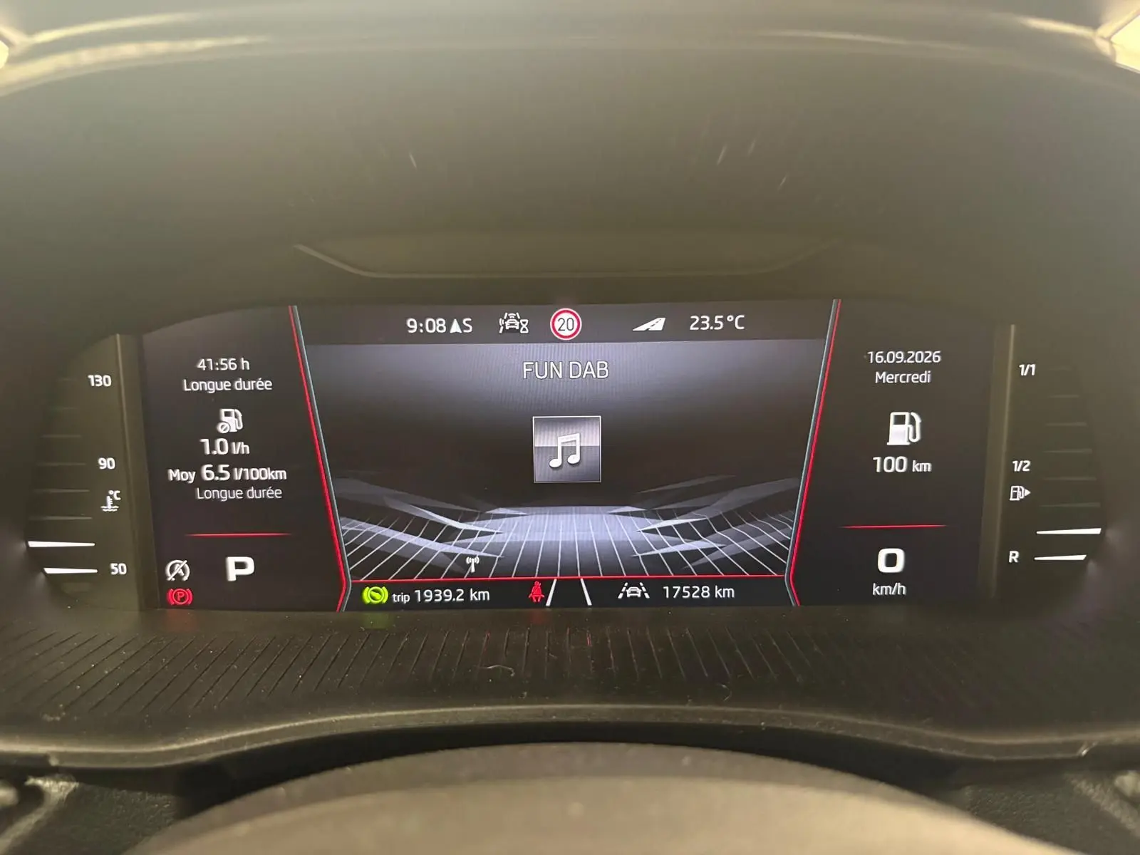 Tableau de bord numérique de Skoda Fabia 1.0 TSI 116 DSG7 Monte Carlo affichant la consommation et la radio, vue de face.