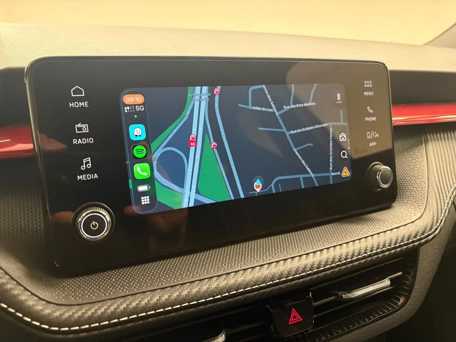 Écran tactile central affichant la navigation, sur tableau de bord noir avec insert rouge dans une Skoda Fabia Monte Carlo 2025.