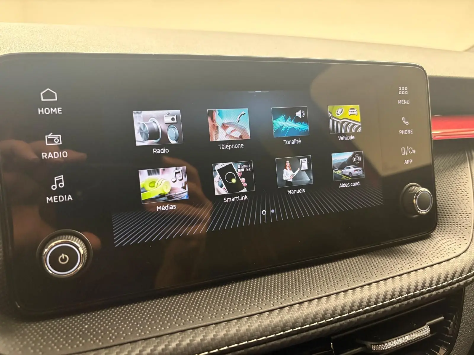 Écran tactile central du tableau de bord de la Skoda Fabia 2025, affichant les menus multimédia et assistance.