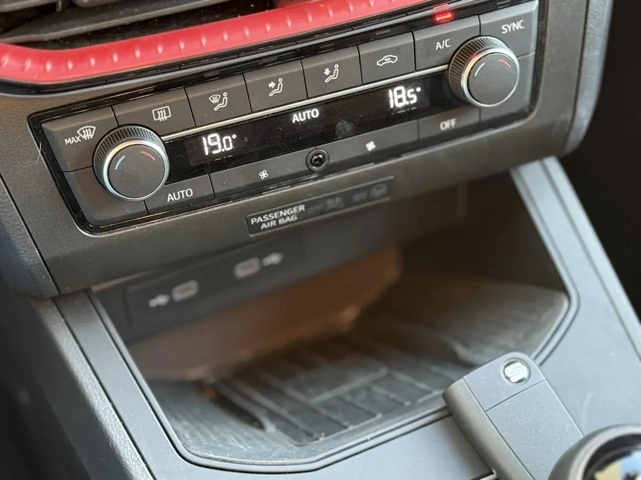 Détail de la console centrale du SEAT IBIZA TSI 115 FR 2025 montrant la climatisation automatique bi-zone et le chargeur à induction noir.