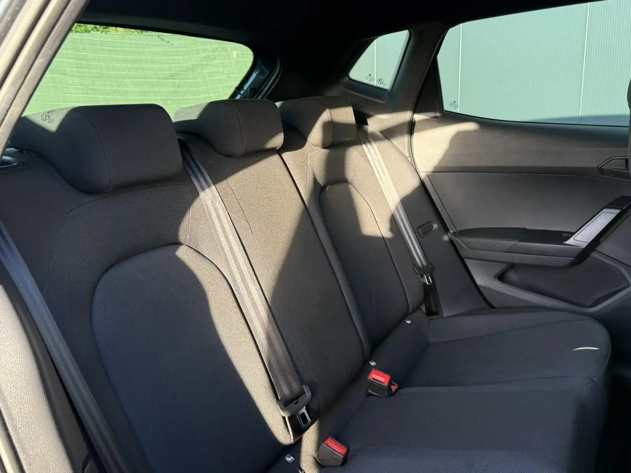 Banquette arrière noire vue côté droit dans une SEAT IBIZA TSI 115 FR 2025, avec ceintures de sécurité visibles.