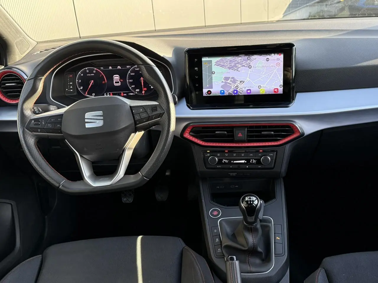 Intérieur de la SEAT IBIZA TSI 115 FR 2025, vue du tableau de bord avec écran tactile et levier de vitesses manuel.