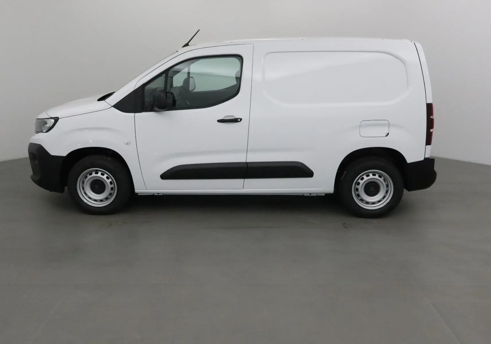 Peugeot Partner blanc en vue profil côté gauche, utilitaire compact avec protections latérales noires.