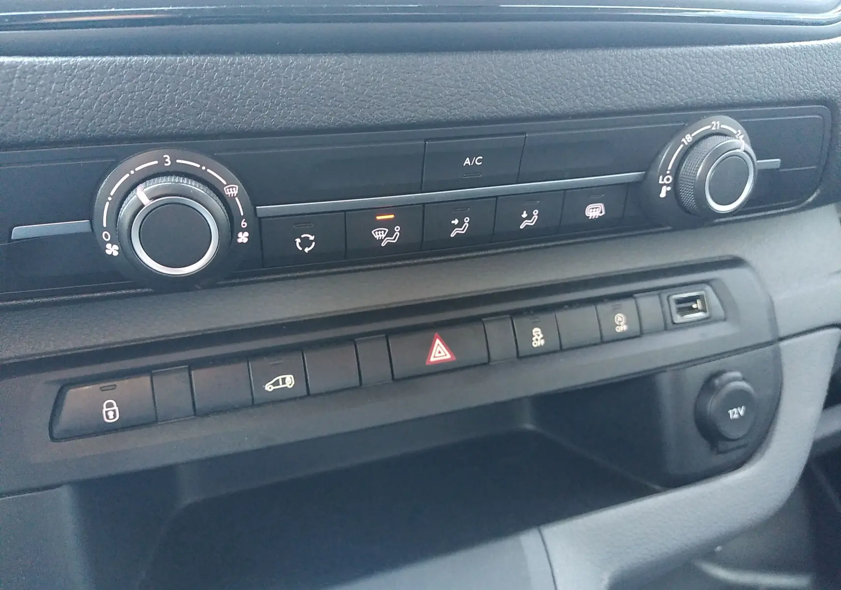 Vue rapprochée du tableau de bord noir du Citroën Jumpy 2021 montrant les commandes de climatisation et les boutons de fonction.