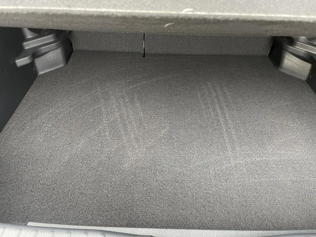 Coffre vide de Toyota Yaris Cross gris clair, vue intérieure montrant le plancher plat et l'espace de chargement.