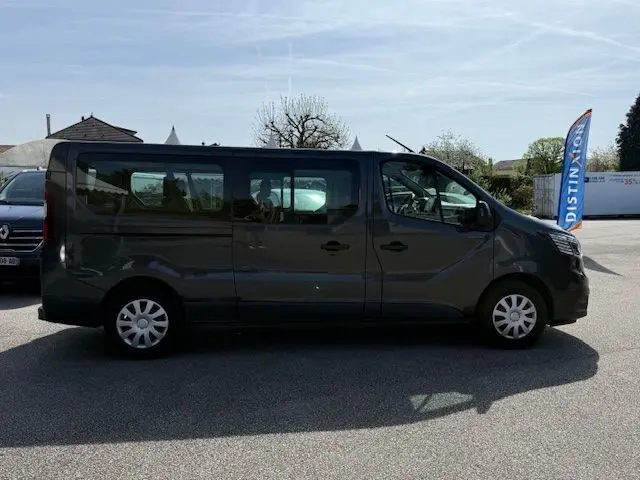 Profil droit d'un Renault Trafic Combi gris comète 2022, version 9 places, avec fenêtres latérales et jantes acier.