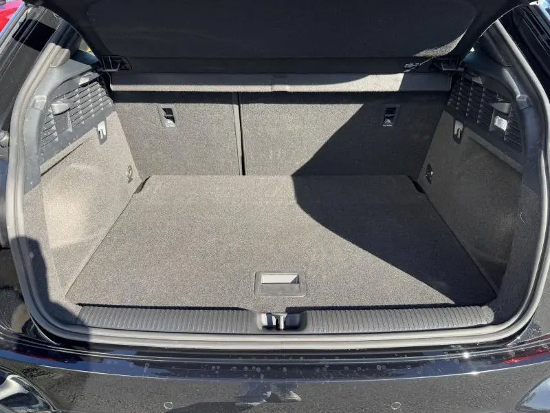 Coffre ouvert vu de l'arrière d'un Audi Q2 30 TDI noir Mythic métallisé, espace de chargement propre et spacieux.