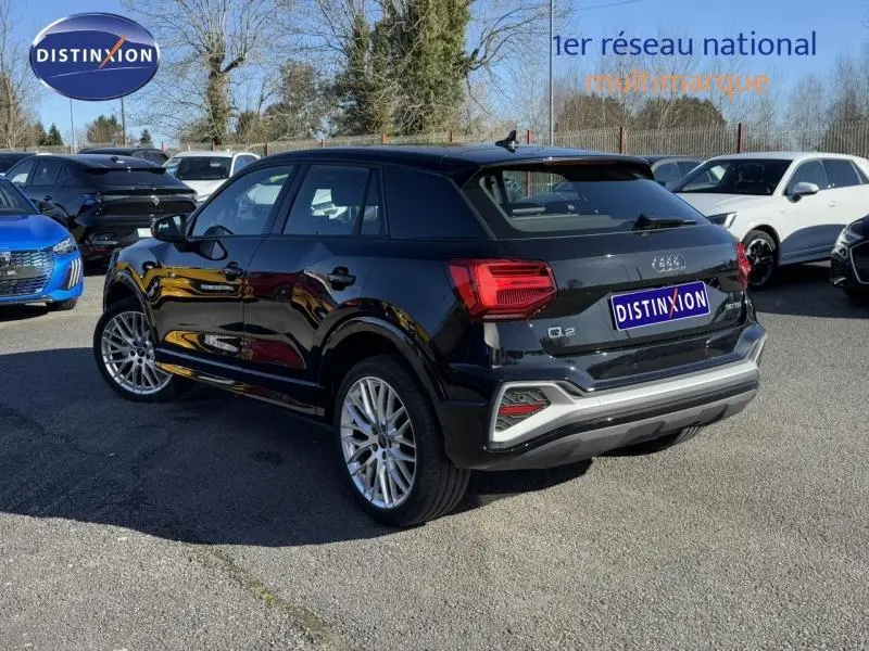 Audi Q2 30 TDI S line noir Mythic métallisé vue 3/4 arrière droit avec jantes alu et feux LED distinctifs.