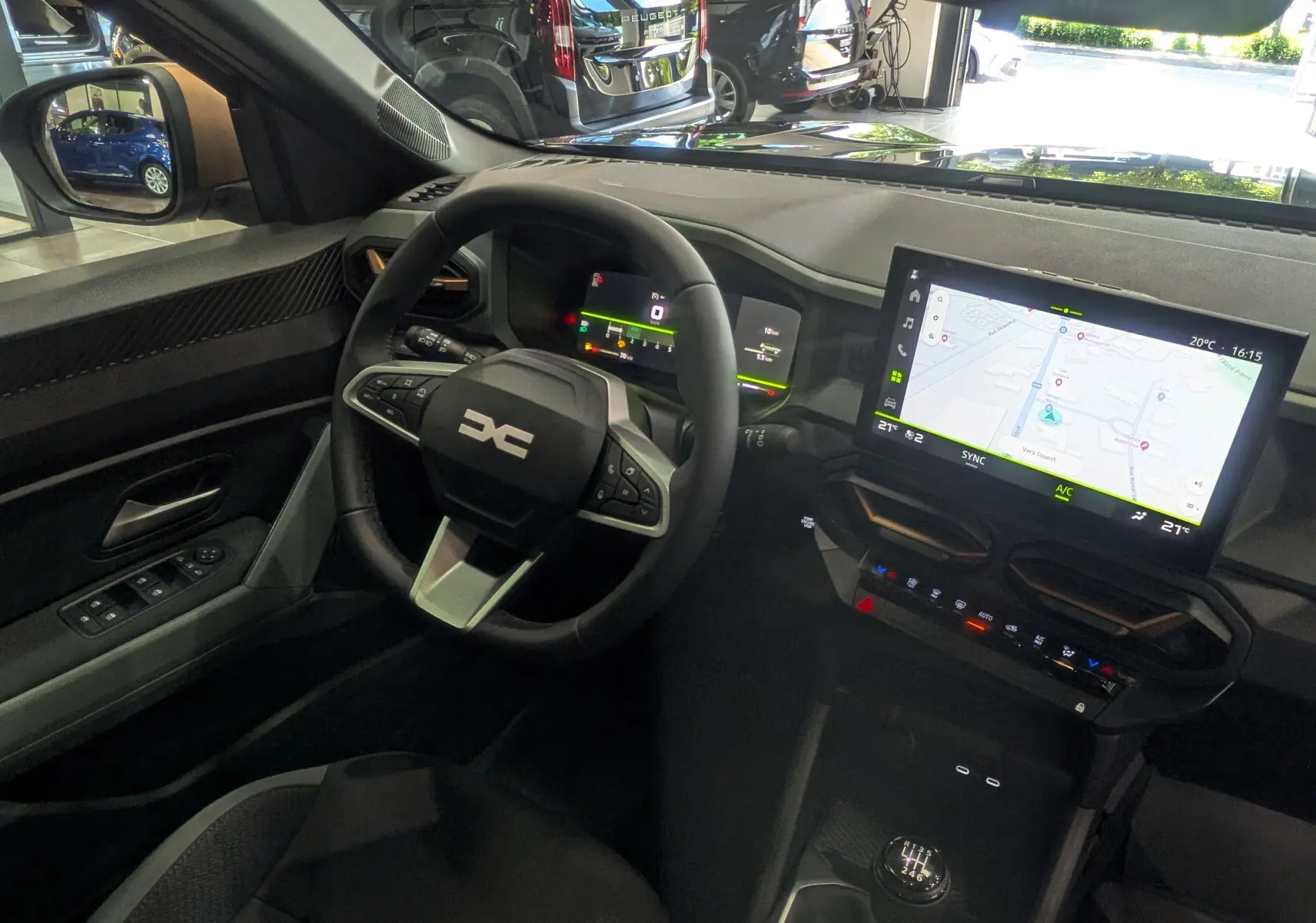 Vue intérieure côté conducteur du Dacia Bigster gris schiste 2026, avec volant multifonction, écran tactile et boîte manuelle.