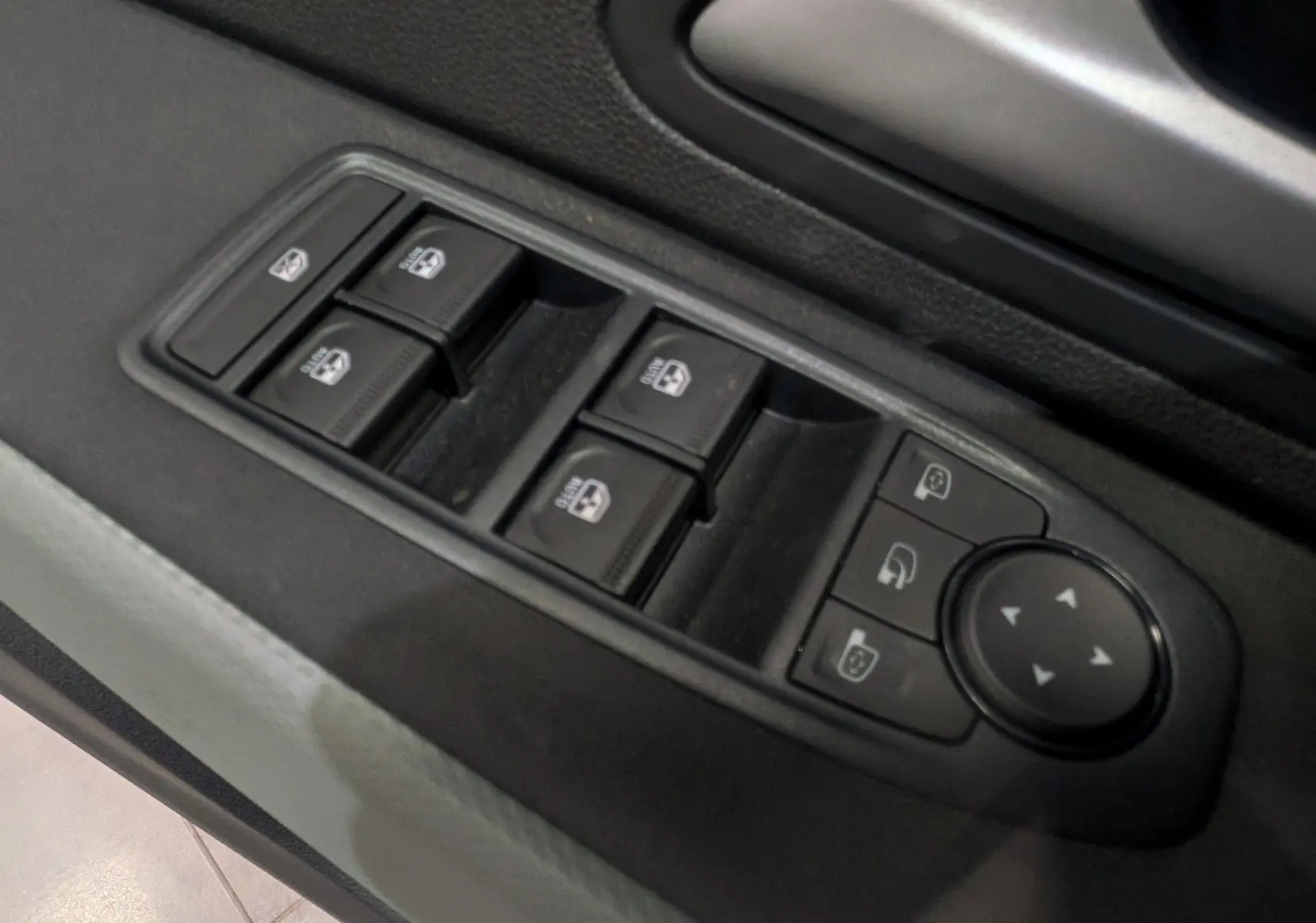 Gros plan sur les commandes des vitres et rétroviseurs côté gauche intérieur du Dacia Bigster gris schiste 2026.