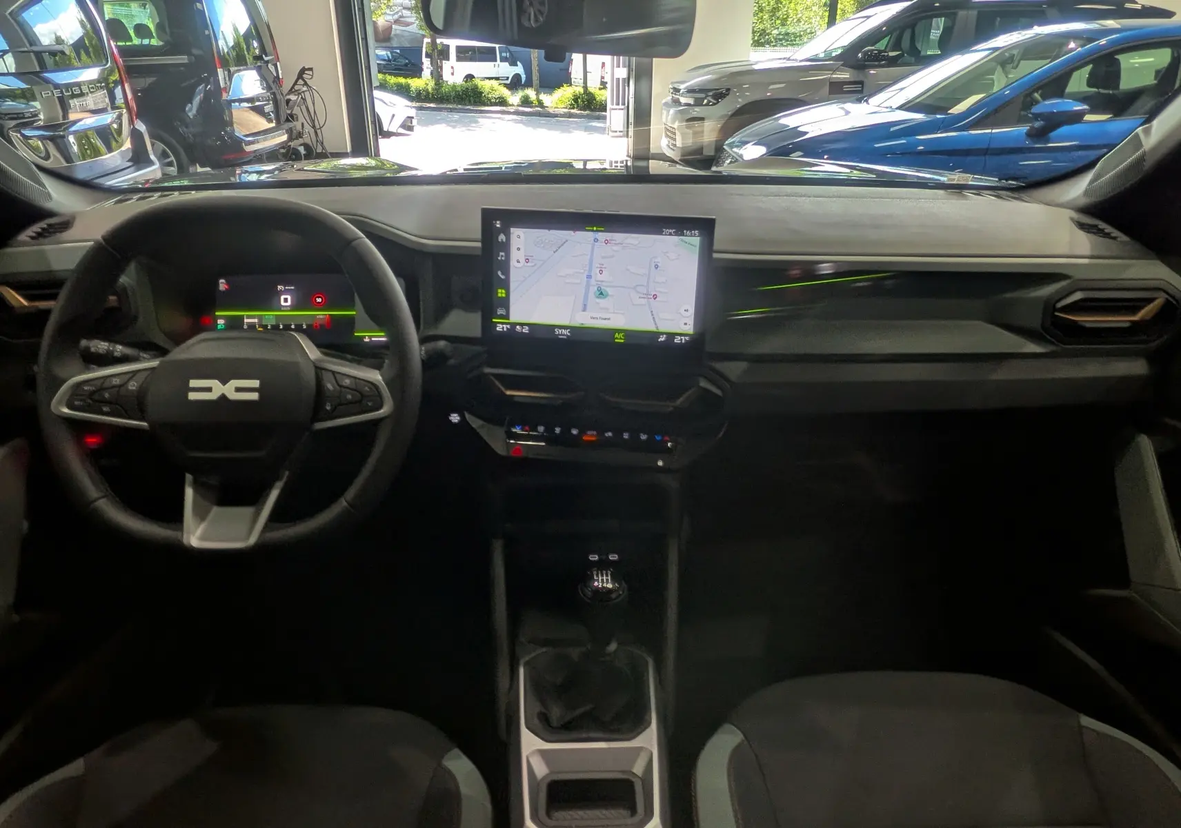 Vue intérieure avant du Dacia Bigster gris schiste 2026, avec tableau de bord numérique et écran central tactile affichant la navigation.