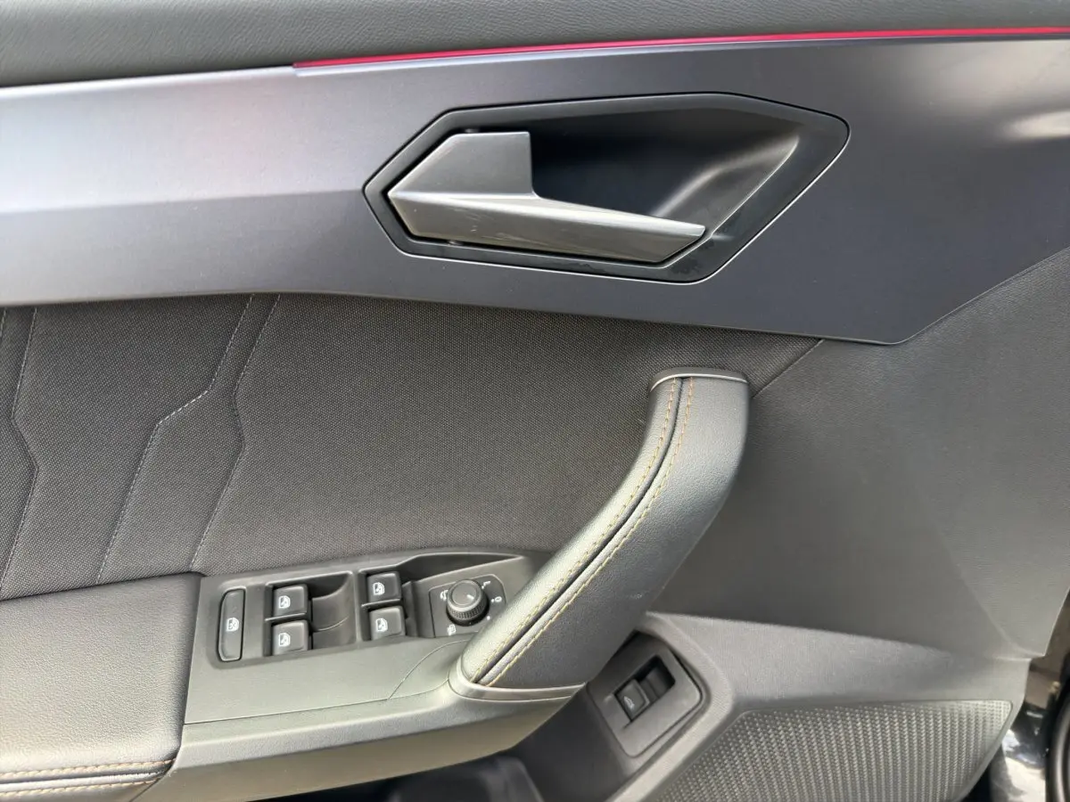 Gros plan sur la porte côté conducteur de la CUPRA Formentor 2025, avec poignée alu et commandes électriques noires.
