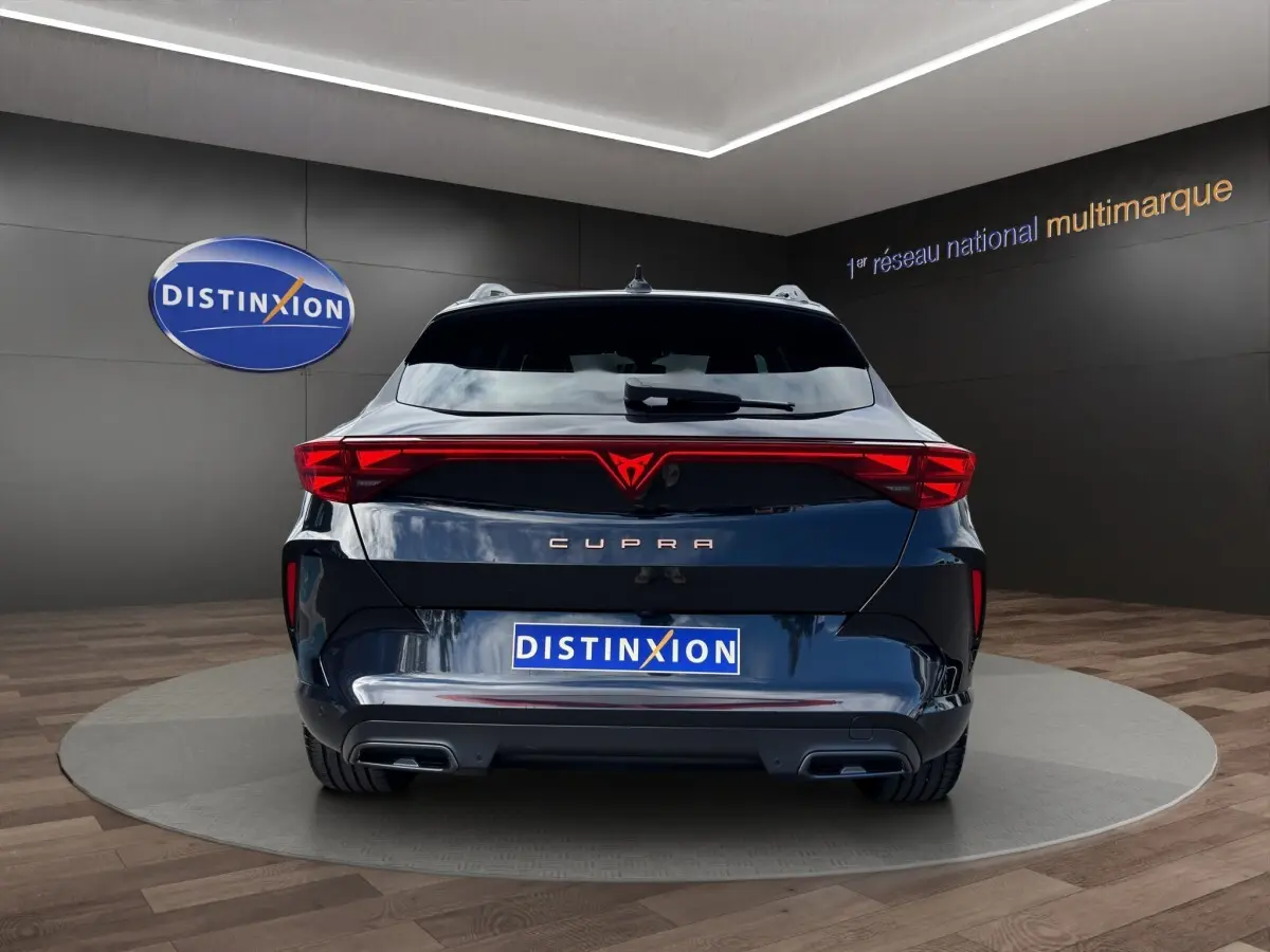 Vue arrière d'une CUPRA Formentor noire avec feux LED reliés et double sortie d'échappement intégrée.