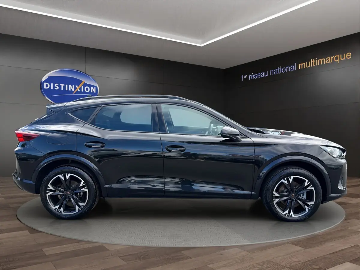Vue latérale droite d'un CUPRA Formentor noir brillant avec jantes alliage distinctives en showroom.