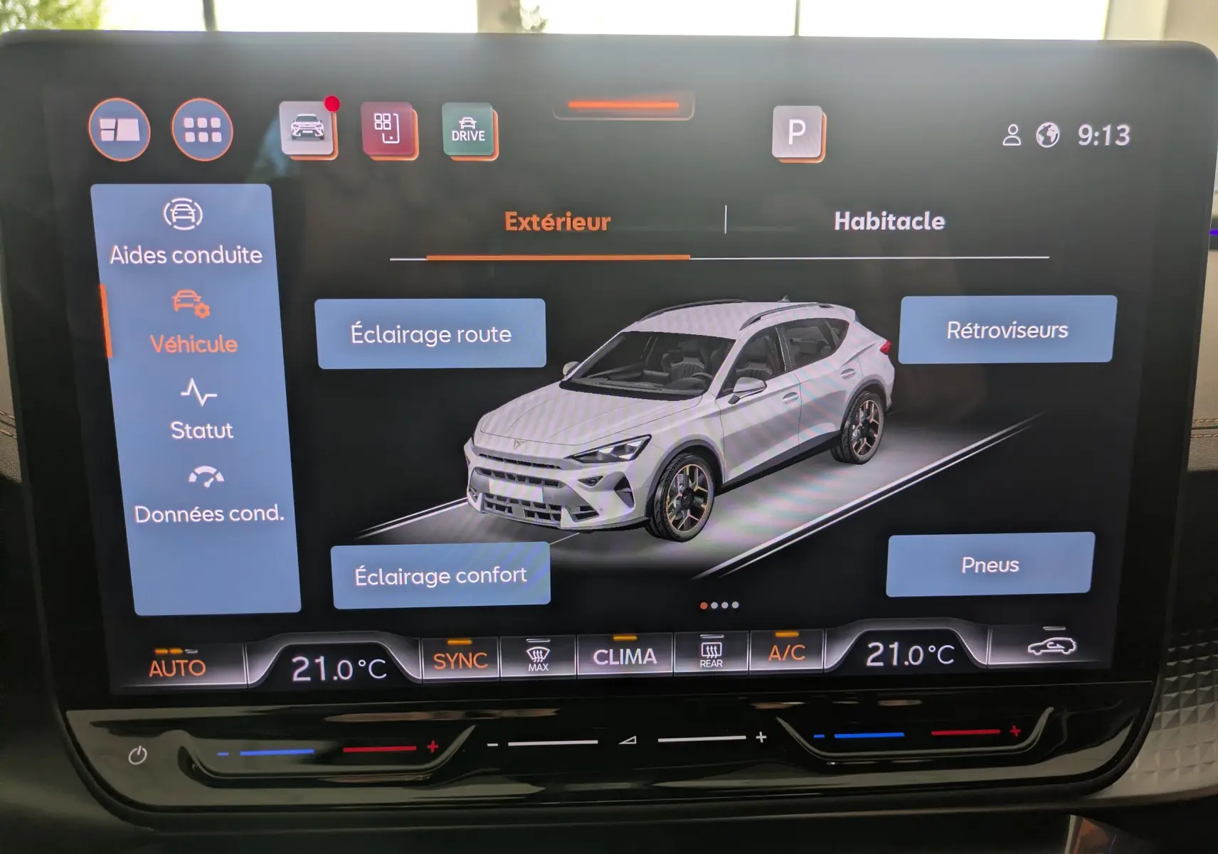 Écran tactile intérieur montrant une vue 3/4 avant d'une CUPRA Formentor gris magnétique avec options d'éclairage et rétroviseurs.