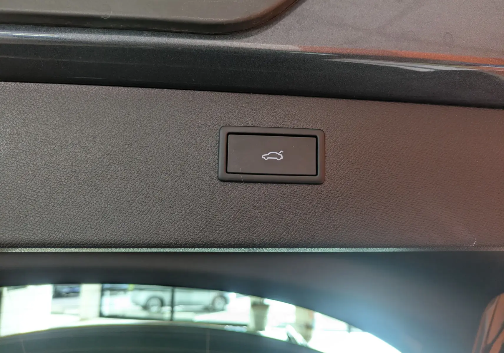 Bouton d'ouverture électrique du hayon sur la garniture intérieure arrière d'un CUPRA Formentor gris magnétique.