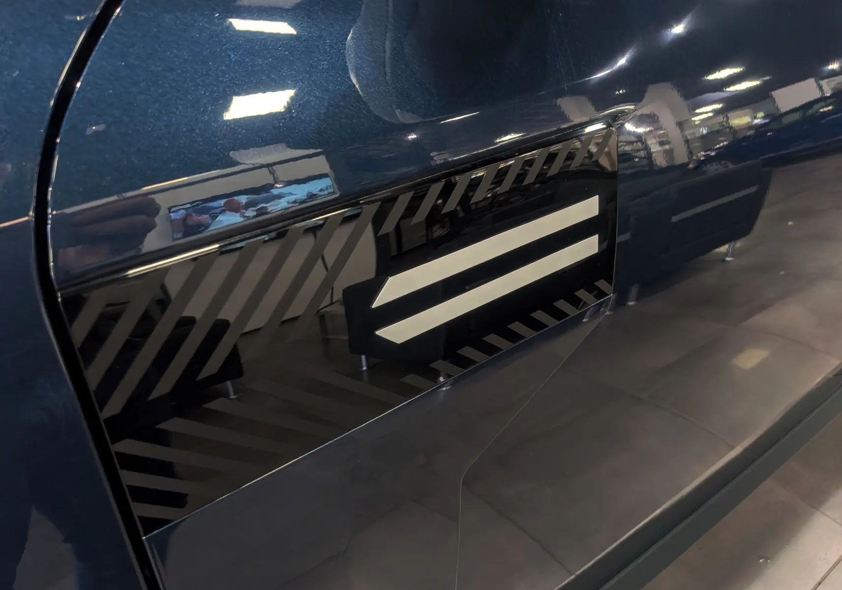 Détail du côté gauche bleu indigo du Dacia Bigster 2026 avec insert noir à motifs diagonaux.
