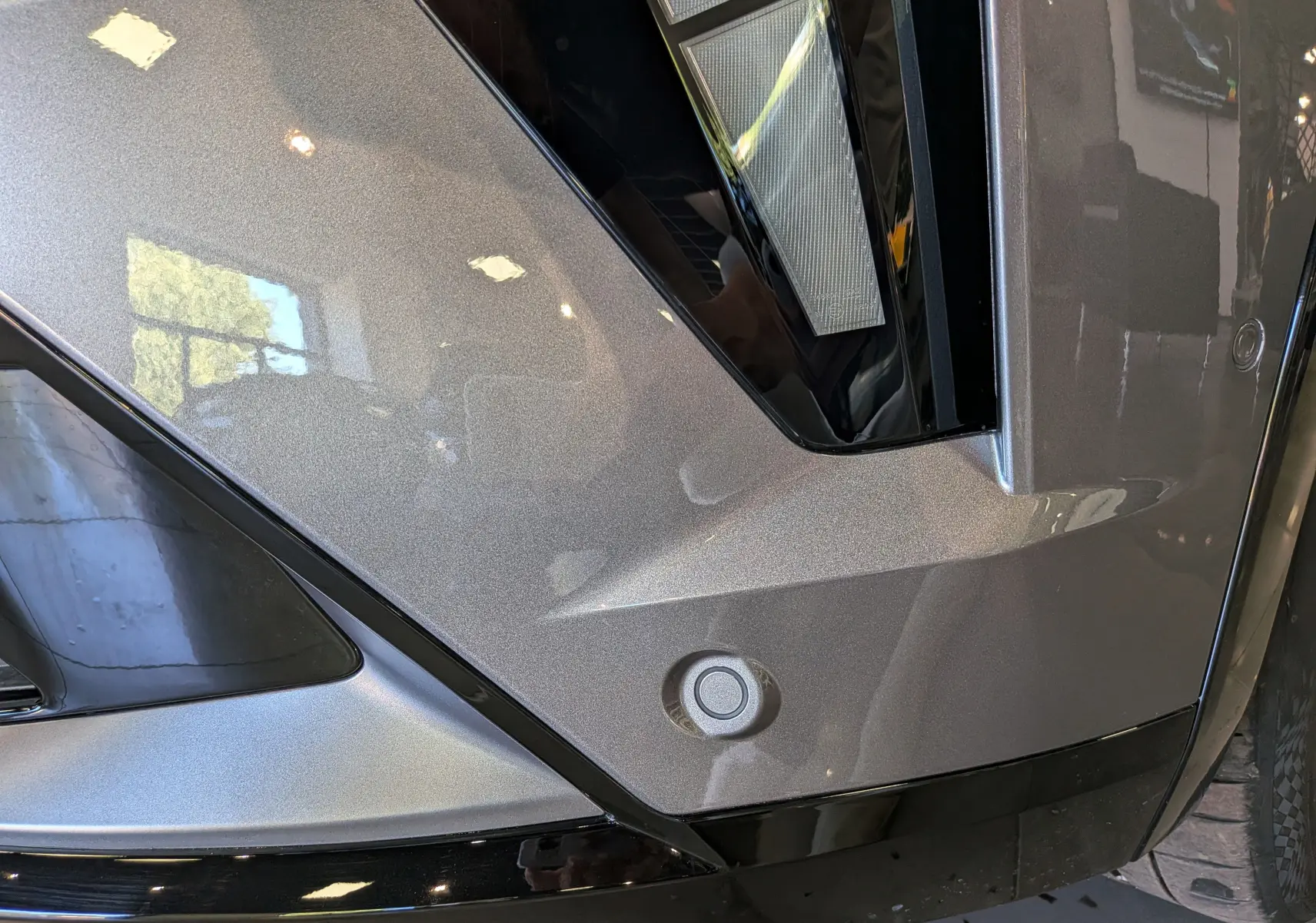 Détail du pare-chocs avant gris schiste de la Renault Rafale 2026 avec capteur de stationnement et éclairage LED.