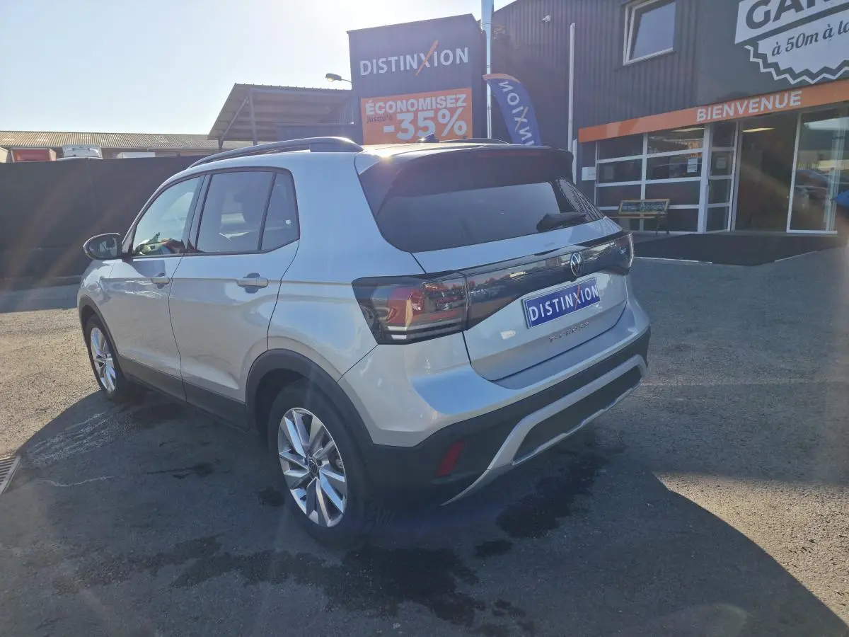 Volkswagen T-Cross gris métallisé vue 3/4 arrière droit, avec jantes alliage 17 pouces et feux arrière LED teintés.