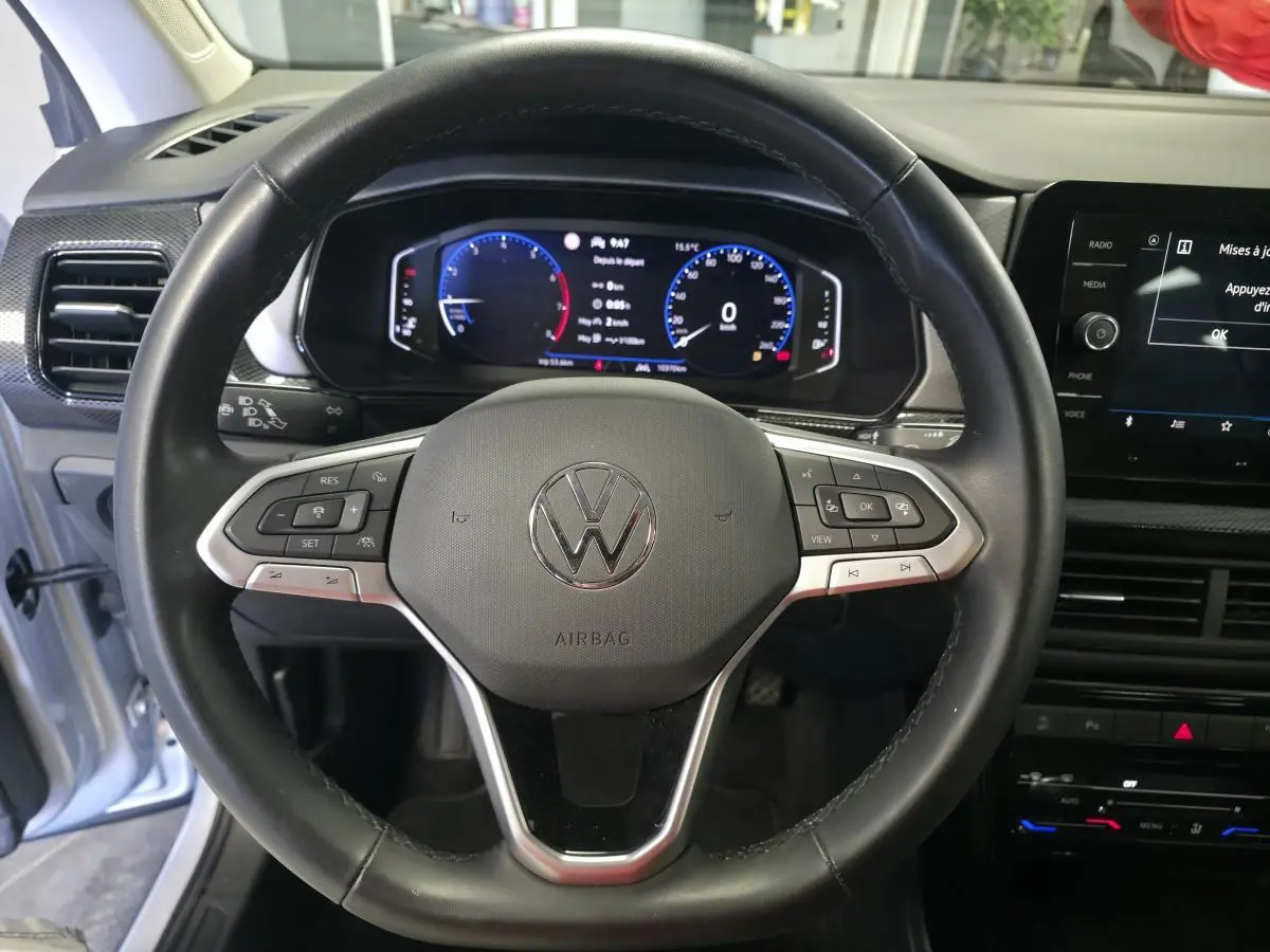 Vue rapprochée du volant en cuir noir et du combiné digital du Volkswagen T-Cross gris 2025, version Life.