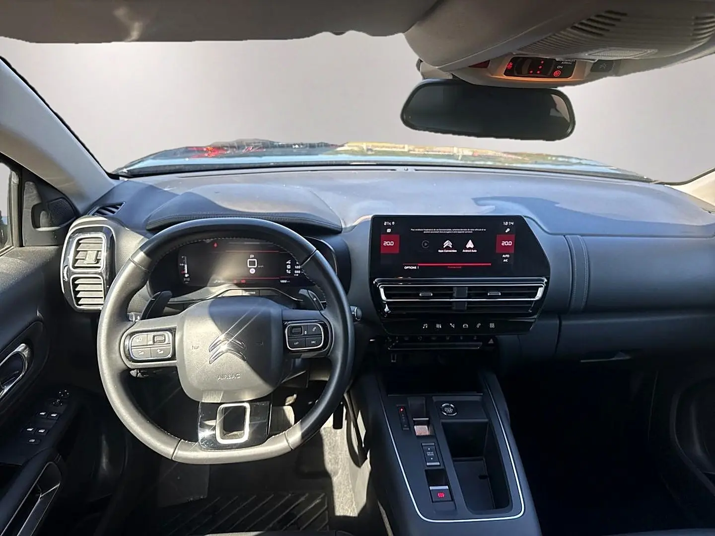 Vue intérieure avant du tableau de bord noir du Citroën C5 Aircross 1.2 hybride avec écran tactile et volant multifonction.
