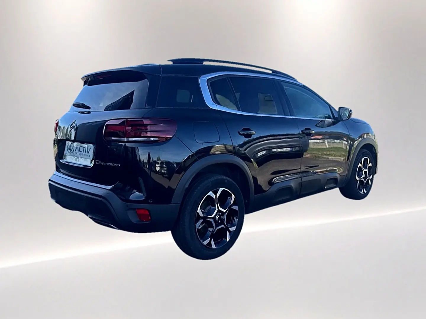 Vue 3/4 arrière droite du Citroën C5 Aircross noir avec barres de toit et jantes alu distinctives.