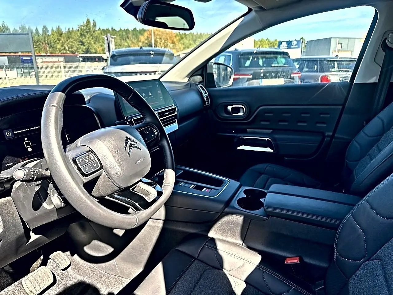 Vue intérieure côté conducteur du Citroën C5 Aircross noir 2025, volant cuir multifonction et écran tactile central visible.