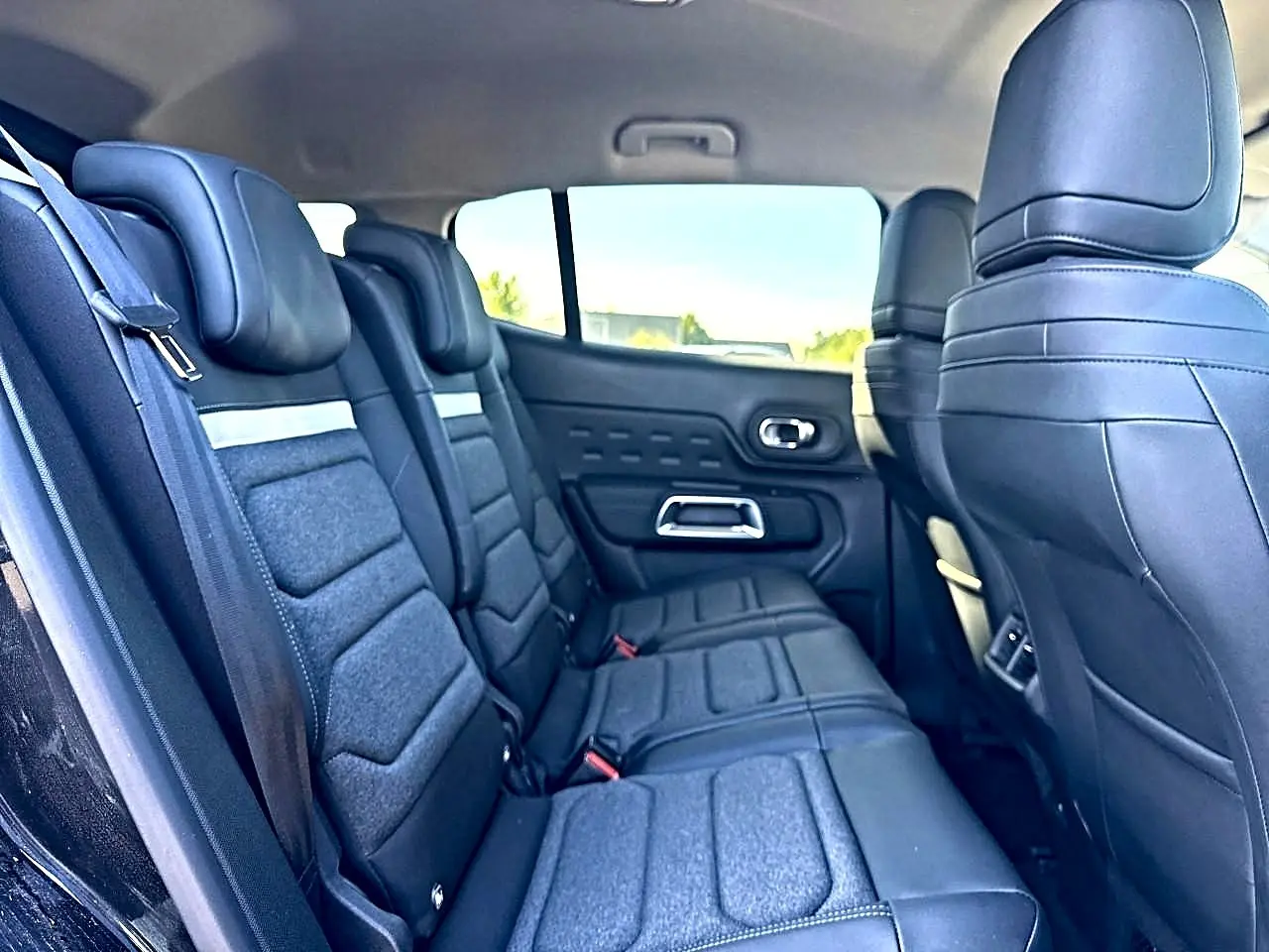 Vue latérale gauche de la 2e rangée de sièges noirs en tissu et cuir du Citroën C5 Aircross 2025 hybride.