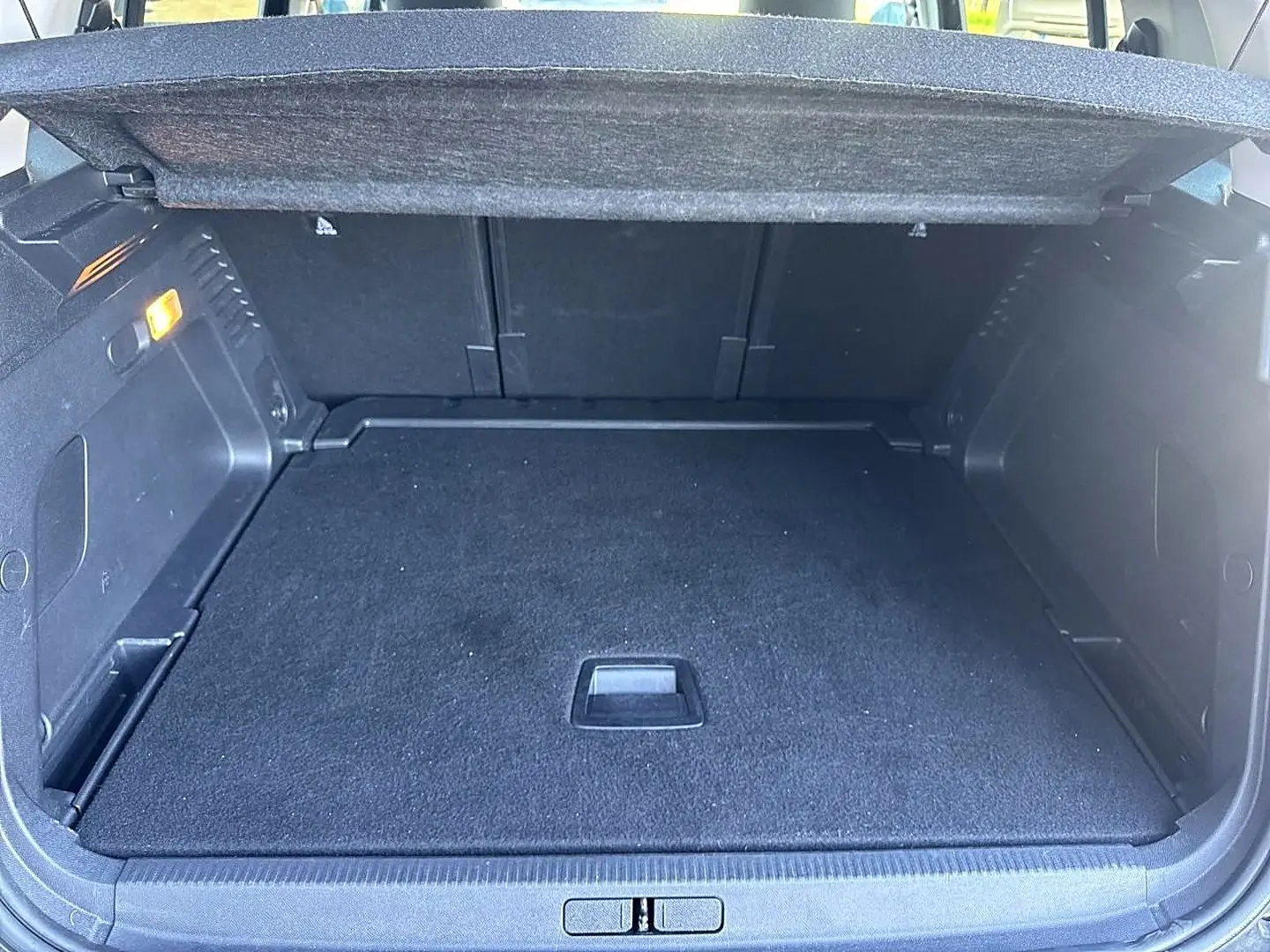Coffre ouvert vu de l'arrière d'un Citroën C5 Aircross noir 2025, espace de chargement vide avec tapis noir.