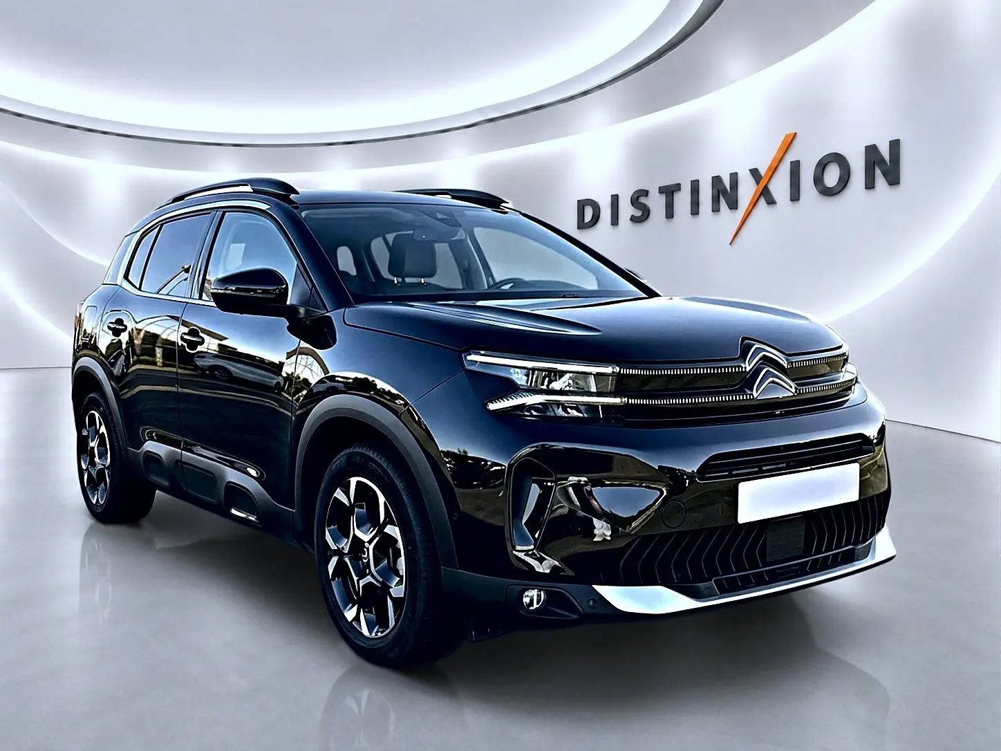 Citroën C5 Aircross noir vue 3/4 avant droit avec barres de toit et jantes alu distinctives.