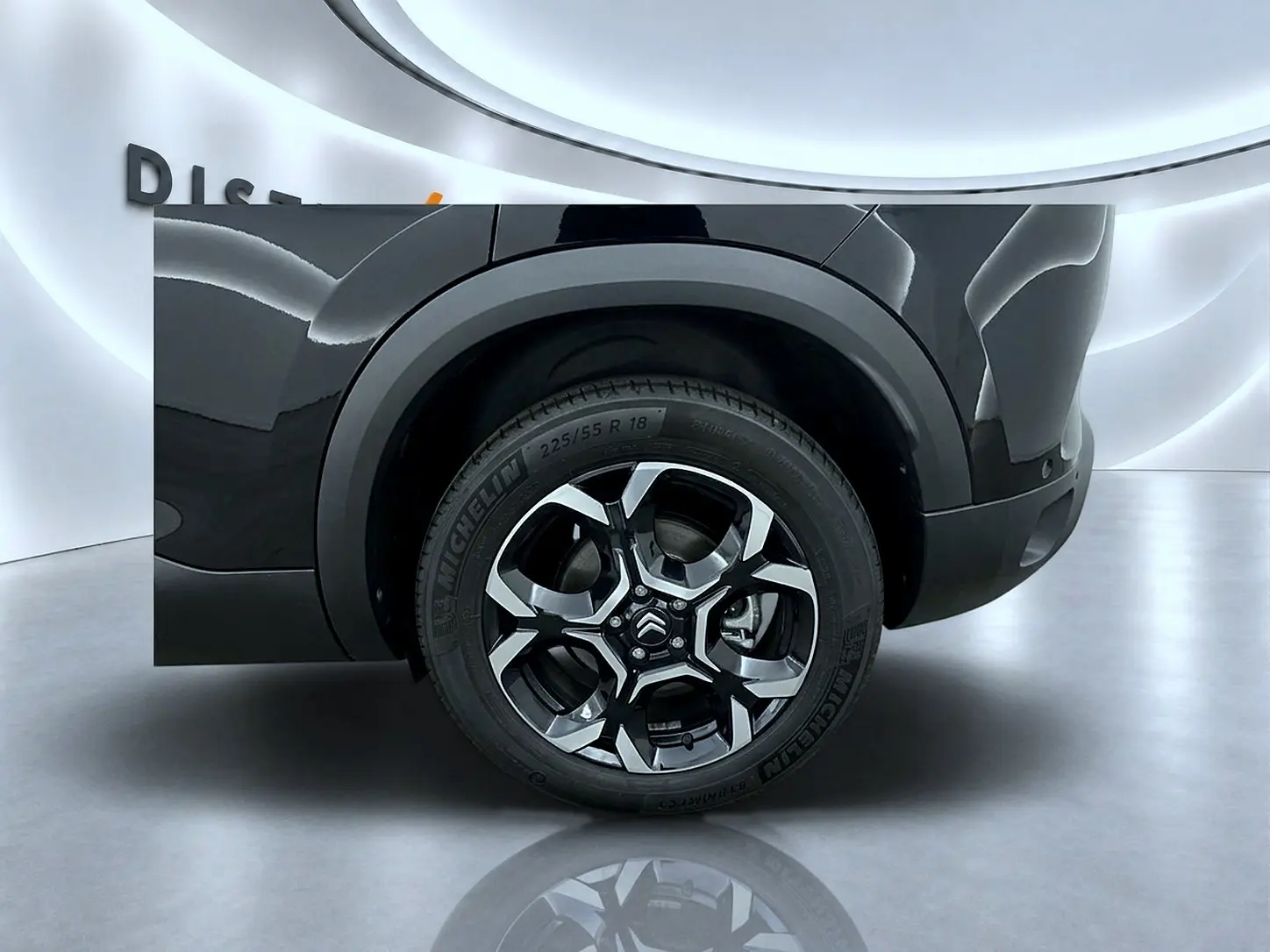 Gros plan sur la roue arrière droite d’un Citroën C5 Aircross noir avec jante alu bicolore et pneu Michelin.