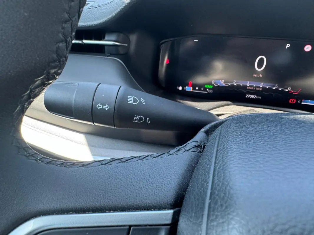 Vue rapprochée du combiné d'instruments et du commodo gauche du Jeep Compass 2025, intérieur noir.
