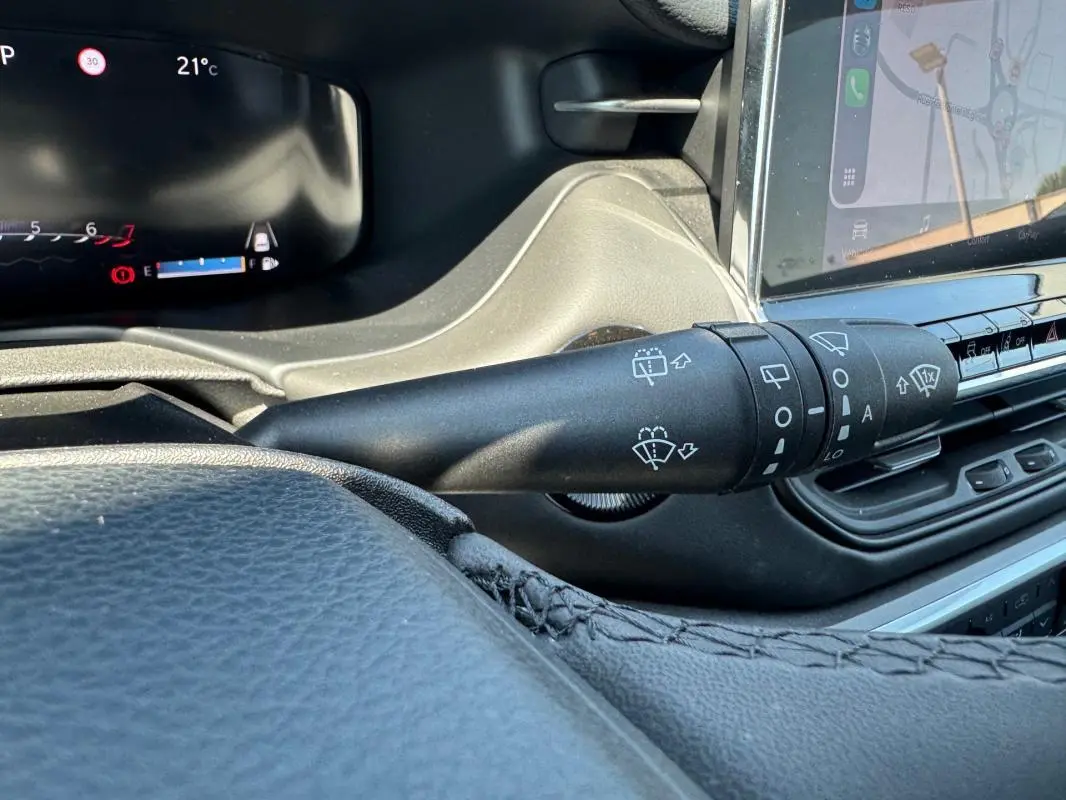 Gros plan sur la commande des essuie-glaces du Jeep Compass 2025, intérieur noir avec écran tactile visible.