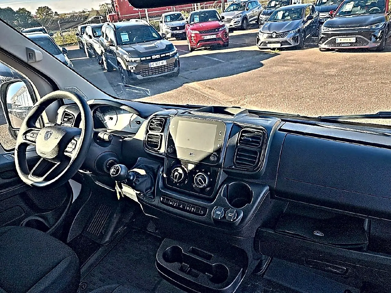 Vue intérieure côté conducteur du Peugeot Boxer Fourgon blanc, montrant le tableau de bord avec écran tactile et volant multifonction.