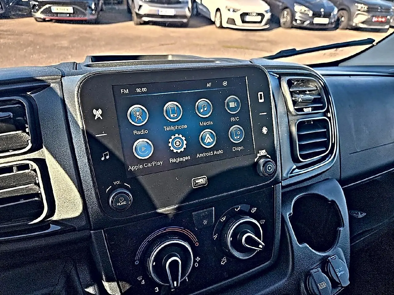 Vue intérieure du tableau de bord du Peugeot Boxer Fourgon L2h2 blanc, avec écran tactile et commandes clim manuelle.