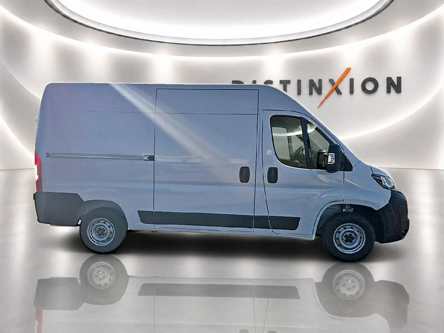 Vue de profil côté gauche d’un Peugeot Boxer Fourgon blanc avec porte latérale coulissante dans un showroom lumineux.
