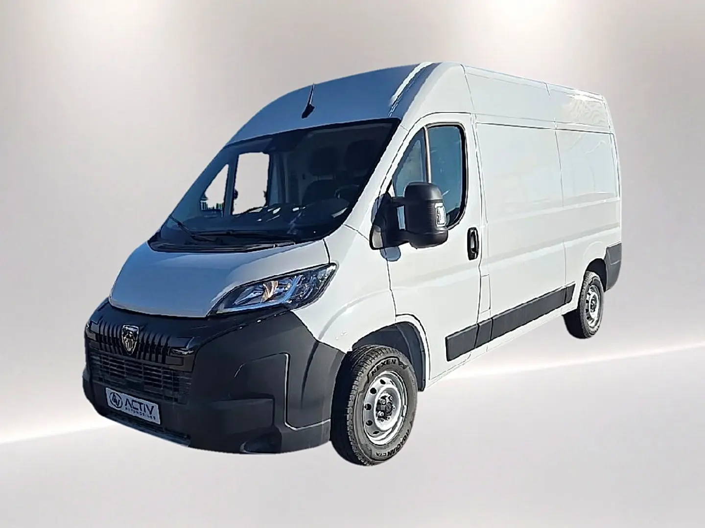 Vue 3/4 avant droit d’un Peugeot Boxer Fourgon blanc avec porte latérale coulissante et pare-chocs noir.