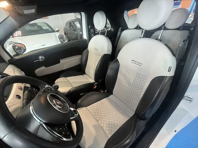 Intérieur de la Fiat 500 blanc, vue côté conducteur montrant sièges bi-couleur noir et blanc avec logo 500 brodé.
