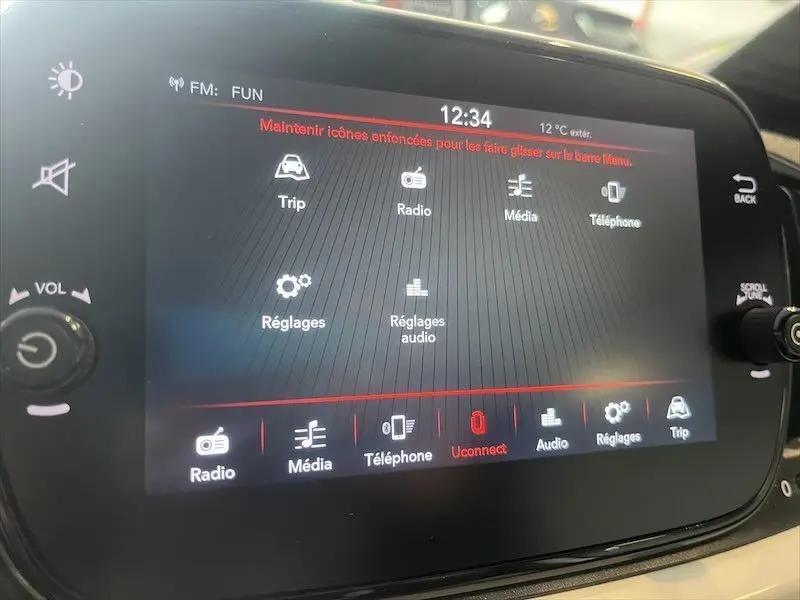Écran tactile central de la Fiat 500 blanche de 2021 affichant les options radio, média, téléphone et réglages audio.
