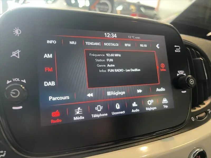 Écran tactile central de la Fiat 500 blanche affichant la radio FM sur la station FUN à 92,6 MHz.