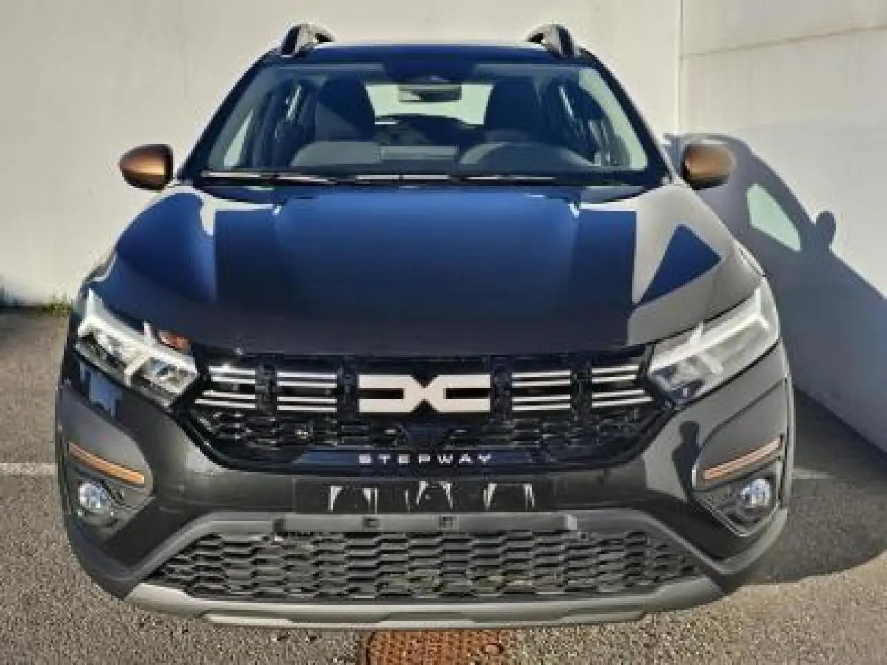 Vue avant d'une Dacia Sandero III Stepway 2025 noir nacré avec calandre noire et inscription Stepway blanche.