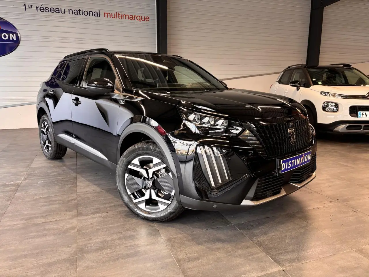 Peugeot 2008 noir en 3/4 avant droit, avec jantes bi-ton et calandre noire distinctive GT.