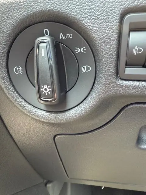 Gros plan sur la molette de commande des phares du Skoda Kamiq 2024, finition Ambition, avec réglage automatique visible.