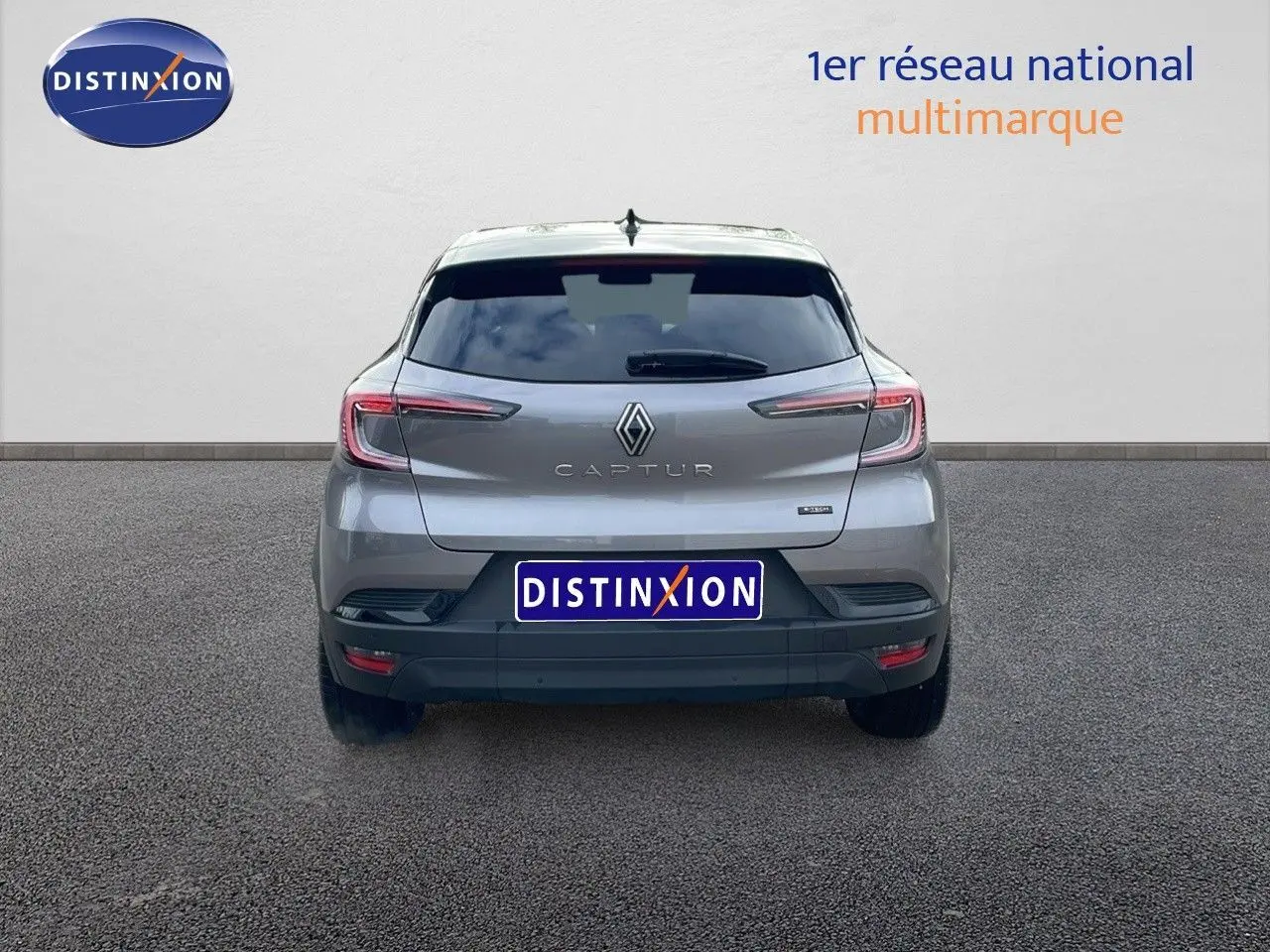 Vue arrière d'un Renault Captur gris Cassiopée métal avec toit noir, affichant le logo et le modèle clairement visibles.