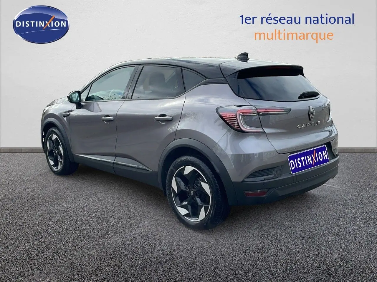 Vue 3/4 arrière droite d'un Renault Captur gris Cassiopée métal avec toit noir, jantes noires et détails modernes.