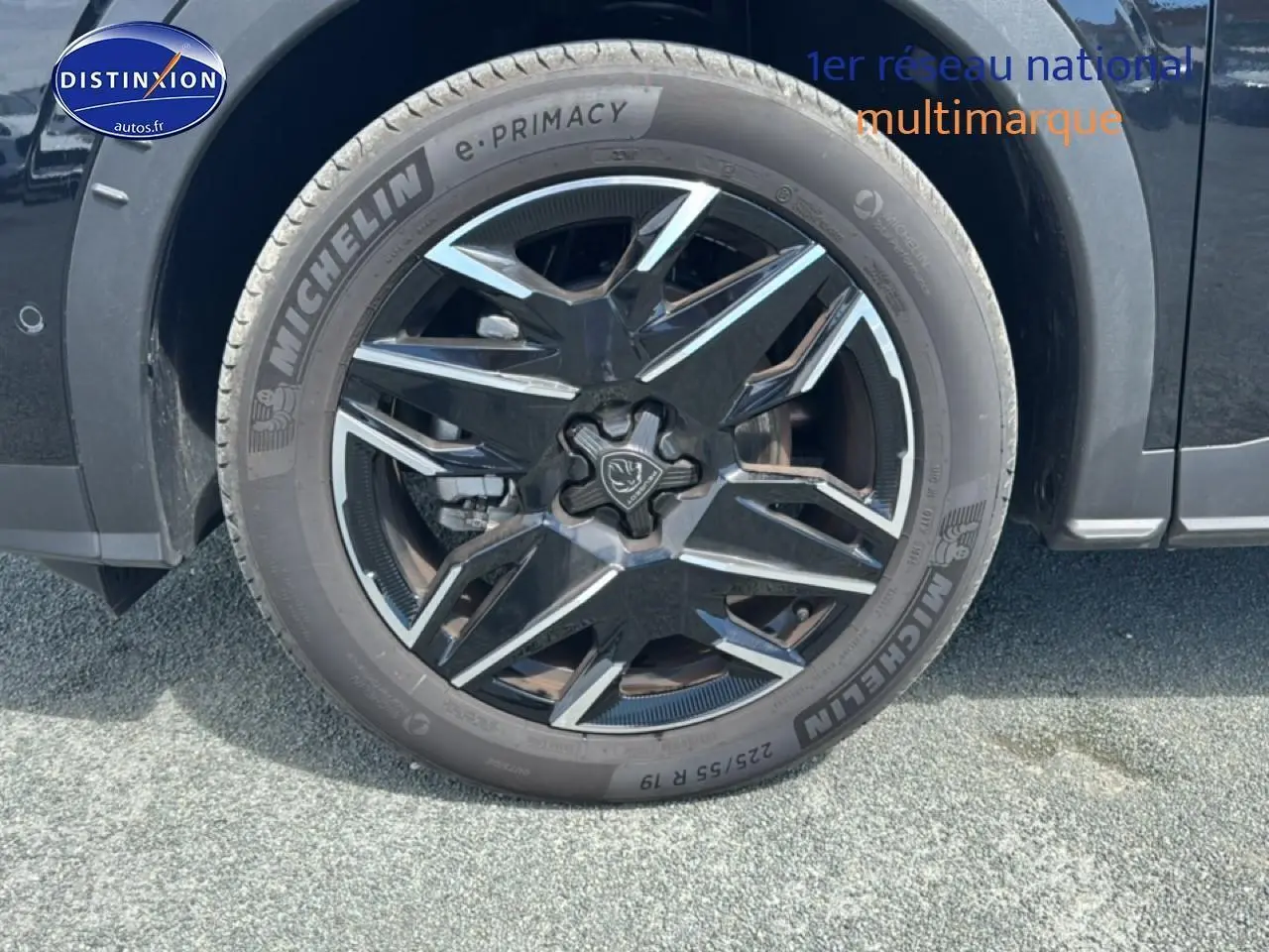 Gros plan sur la roue avant droite noire d’un Peugeot 5008 Hybrid 145 allure e-dcs6 avec jante alu stylisée.